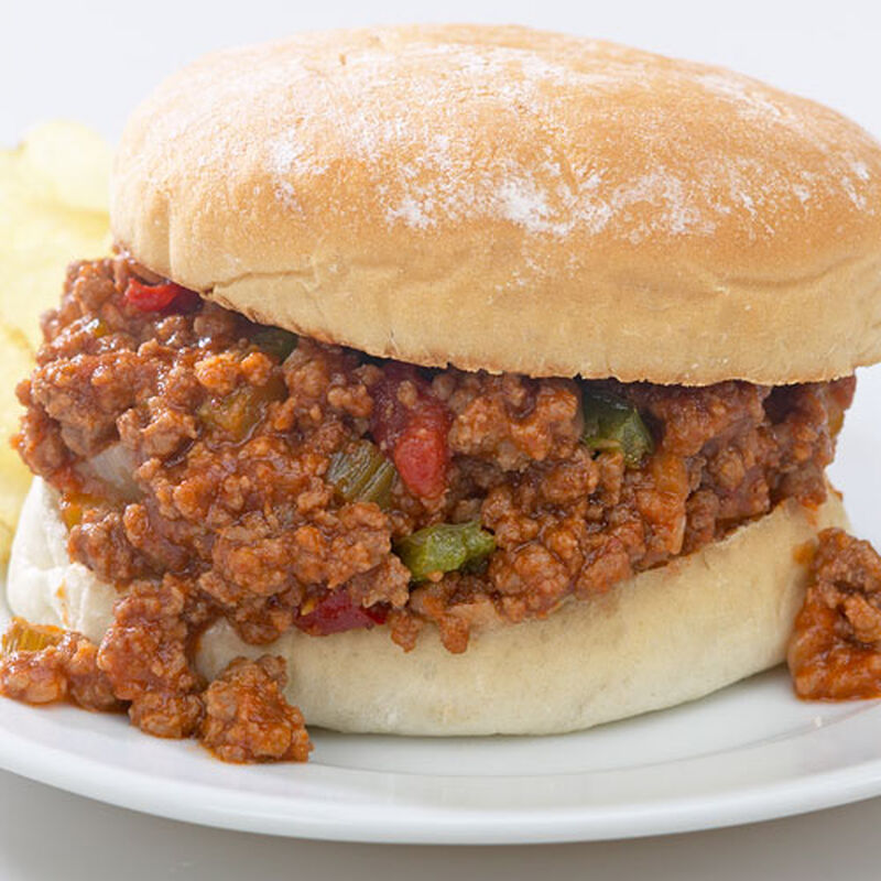close up of a sloppy joe sandwich with the sloppy joe pouring out over the sides