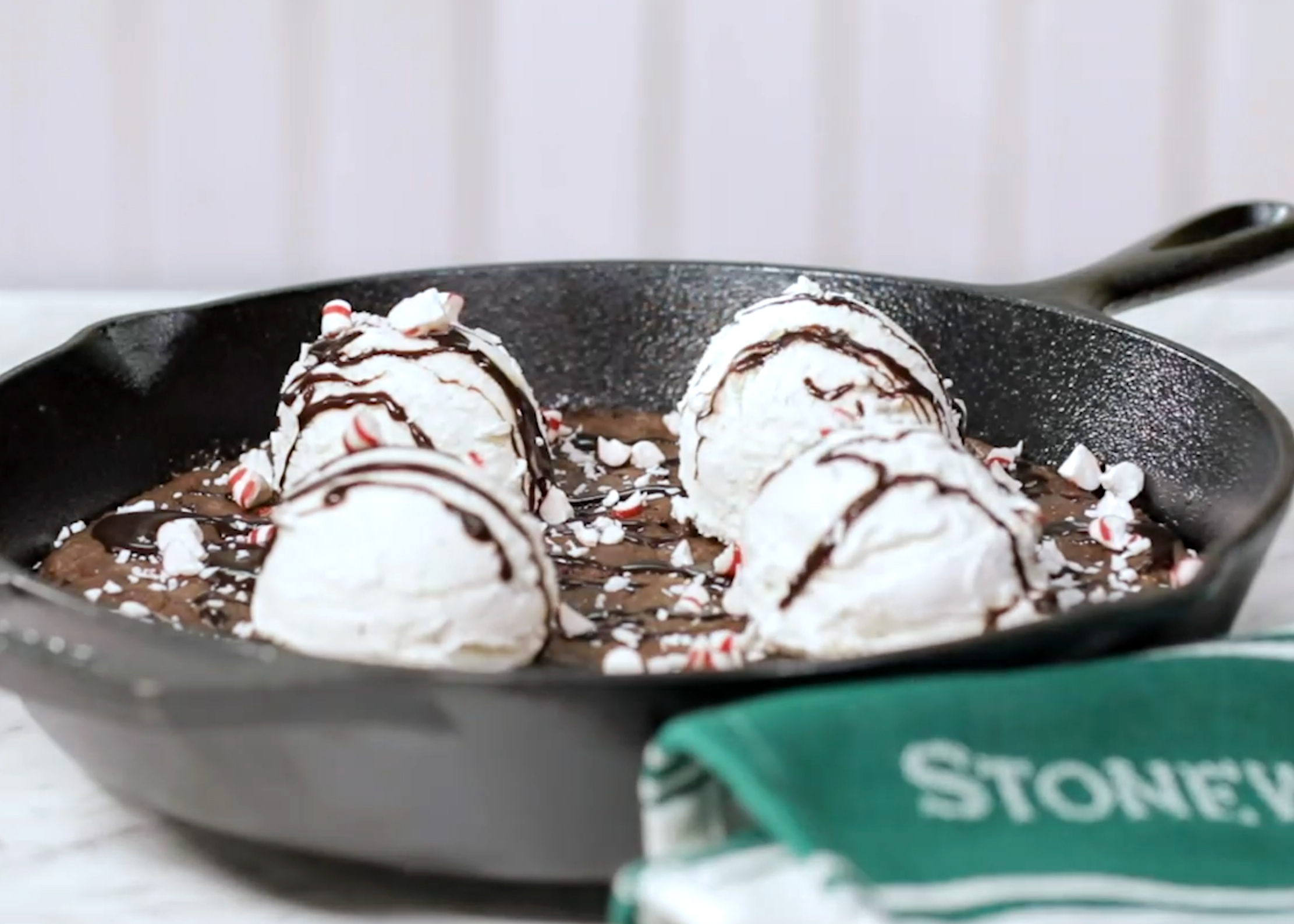 image of our Chocolate Peppermint Skillet Cookie in a cast iron pan on a counter