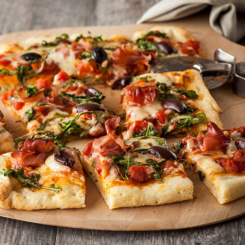 image of a pizza cut into several slices on a circular wooden cutting board