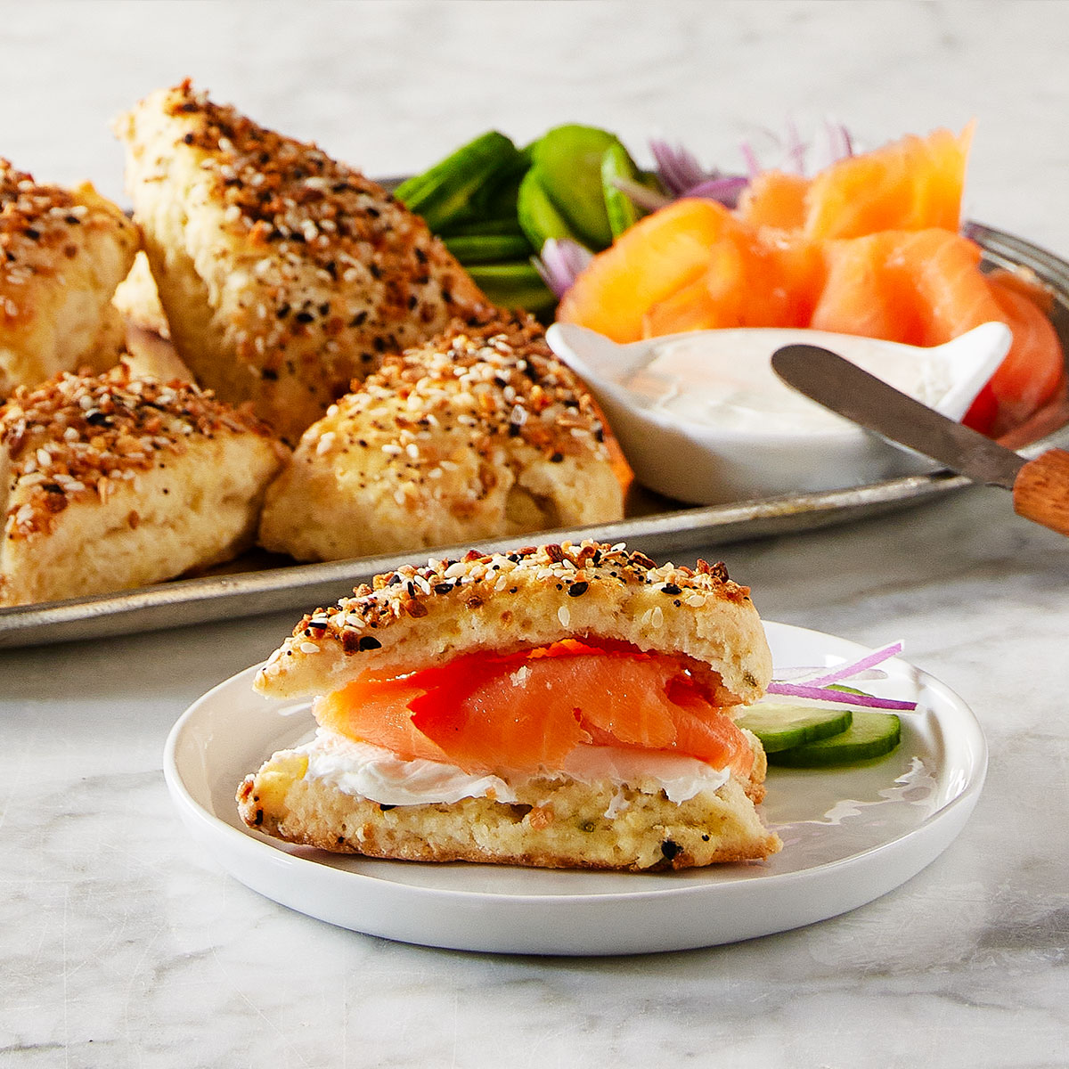 image of a plate of everything flavored scones with one scone in front turned into a small salmon and cream cheese scone sandwich