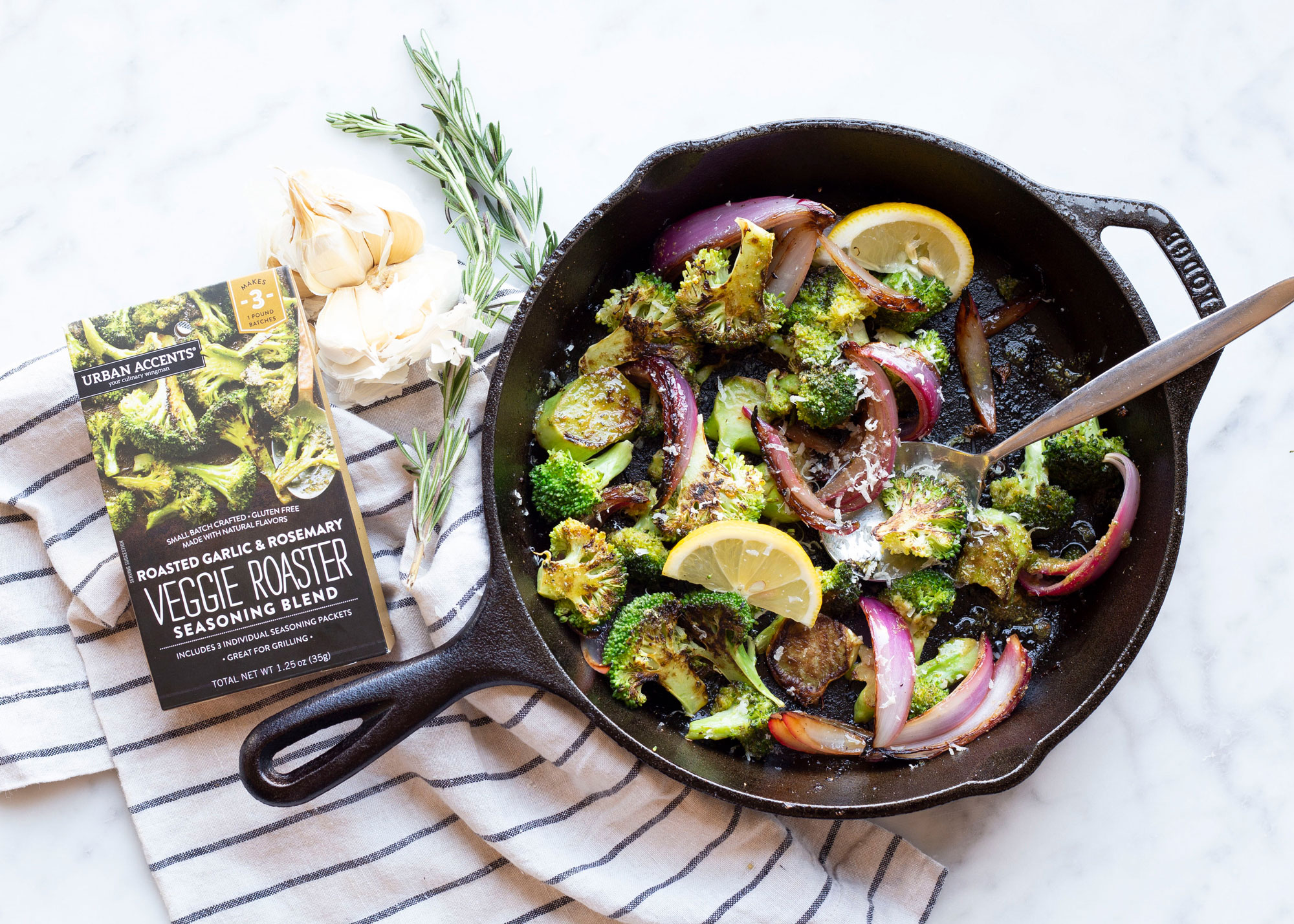 An image of the Rosemary Roasted Broccoli with Red Onions dish in a cast iron skillet on a counter