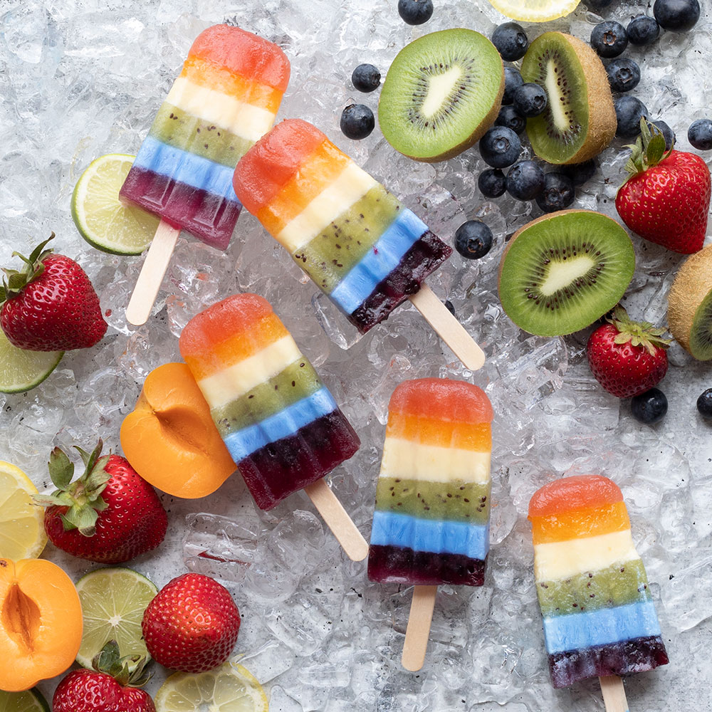 image of homemade popsicles on a bed of ice surrounded by cut fruit