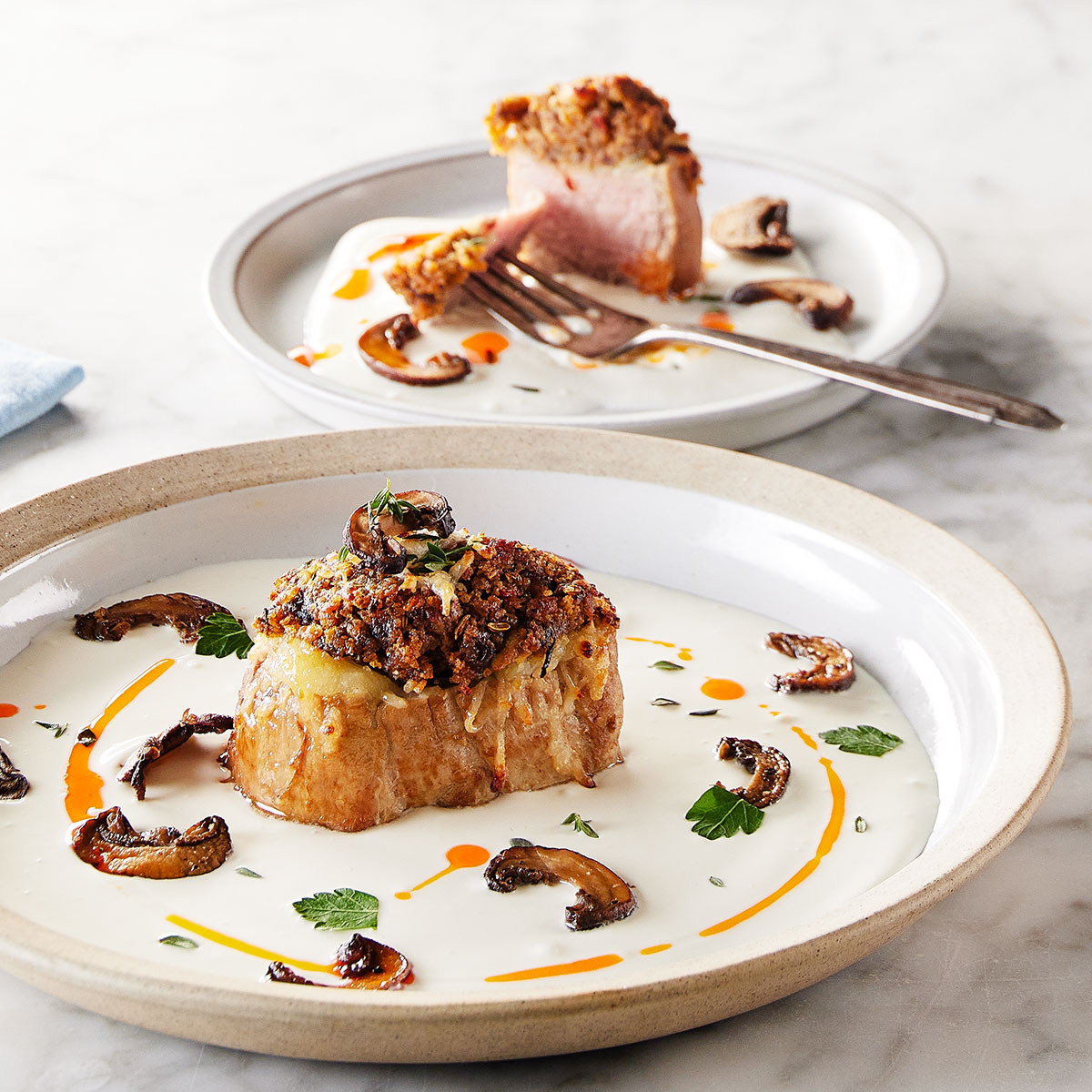 image of pork tenderloin with a pile of stuffed mushroom topping